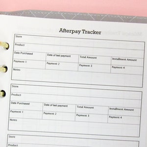 以下が含まれることがあります： 上部に「Afterpay Tracker」というテキストが印刷された、グリッドパターンが施された白い紙。シートは、「ストア」、「商品」、「購入日」、「最終支払日」、「合計金額」、「分割払い金額」、「支払い1」、「支払い2」、「支払い3」、「支払い4」、「メモ」という見出しのついた列に分けられています。