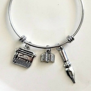 Schrijfarmband: antiekzilveren typemachine-, ganzenveer- en boekbedels