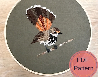 May include: Embroidered hoop art featuring a brown and orange bird with a long tail, perched on a branch. The background is a dark green fabric. The hoop is labeled "PDF Pattern".