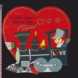 May include: Vintage Valentine's Day card in the shape of a red heart. The card features a cartoon train with a conductor waving from the window. Text reads "I CHOO CHOO CHOOSE YOU" and "LOVE".