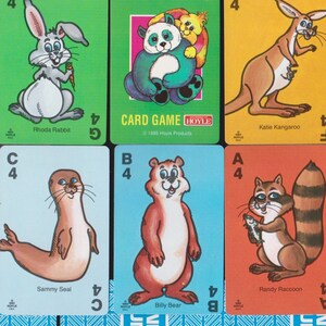 May include: A collection of Animal Rummy playing cards featuring cartoon animals. Each card displays a different animal, including a monkey, rabbit, panda, kangaroo, and otter. The game's title is visible on the top center card and the bottom right card.