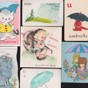 May include: A collection of vintage greeting cards and educational flashcards featuring illustrations of children, animals, and monsters holding umbrellas. The cards include text such as Rain, Umbrella, You're my Valentine, and I like you monstrously.