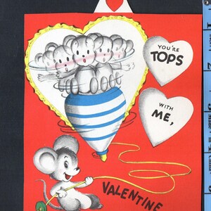 May include: Vintage Valentine's Day card with a red background. The card features a heart-shaped design with cartoon mice on a spinning top. The text "You're Tops" and "With Me" are on white hearts. A mouse pulls a string that says "Valentine".