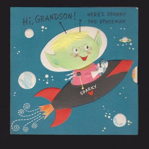 May include: A vintage greeting card featuring a green alien spaceman named Sparky in a rocket ship against a blue space background. The card reads "Hi, Grandson!" and "Here's Sparky the Spaceman."