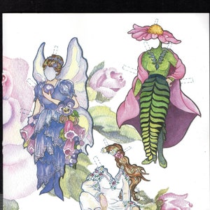 May include: A paper doll set featuring three figures: a blue fairy with wings holding a sphere, a figure with a pink flower head wearing a green leaf-patterned outfit and cape, and a figure in a white dress sitting on a brown turtle.