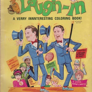 May include: Vintage "Rowan & Martin's Laugh-In" coloring book cover. The yellow cover features cartoon illustrations of two men in blue suits, holding top hats and canes. Text includes "A VERRY INNNTERESTING COLORING BOOK!"