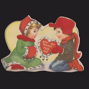 May include: Vintage Valentine's Day card featuring two children. One child wears a green coat and red hat, the other a red hat and plaid shirt. A heart-shaped message reads "you are meant FUR me."