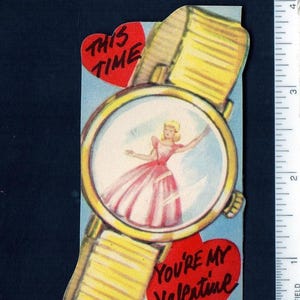 May include: A vintage-style paper valentine card shaped like a wristwatch with a yellow band and gold-tone face. Inside the watch face is an illustration of a person in a pink dress. Text reads THIS TIME and YOU'RE MY VALENTINE. Measures 4.5 inches.