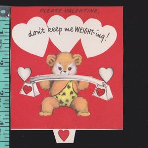 May include: A red Valentine's Day card featuring a brown teddy bear wearing a yellow and black leopard print loincloth, lifting a barbell with heart-shaped weights. The text reads, PLEASE VALENTINE, don't keep me WEIGHT-ing! A ruler shows a height of 4 inches.