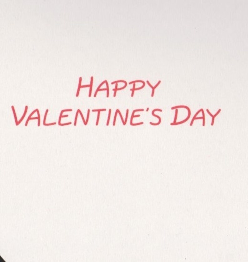 May include: A white background with the red text "HAPPY VALENTINE'S DAY" in a handwritten style. The text is centered and takes up a significant portion of the image, suitable for a Valentine's Day card or message.