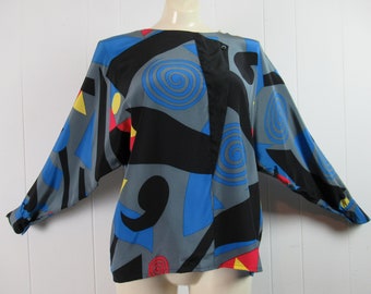 May include: A gray, blue, black, red, and yellow abstract print blouse with long sleeves and a button closure.