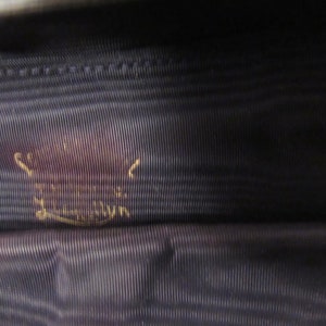 May include: Close-up of a dark blue fabric with a gold inscription that reads "Made in London".