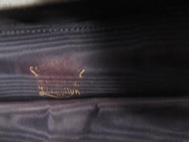 May include: Close-up of a dark blue fabric with a gold inscription that reads "Made in London".