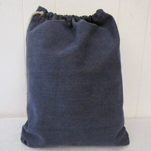 K&ouml;nnte beinhalten: Eine dunkelblaue Kordeltasche aus Canvas mit einem wei&szlig;en Kordelzug.