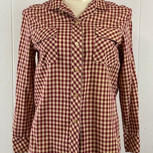 May include: A long-sleeved button-down shirt with a red and white gingham pattern. The shirt has two chest pockets and a classic collar.