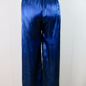 May include: Blue satin pajama pants with a gold trim around the bottom.
