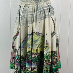 May include: A white skirt with a colorful city scene print and sequins. The skirt is full and has a gathered waist.