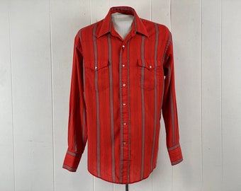 May include: A red and grey striped long-sleeved button-down shirt with two chest pockets and a pointed collar.