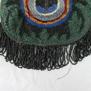 Puede incluir: Un bolso negro de cuentas con un dise&ntilde;o verde y multicolor y un fondo de flecos.