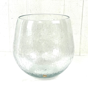 Pode incluir: Uma taça de vidro transparente com uma textura craquelada distinta em todo o seu corpo arredondado. O recipiente tem um topo largo e aberto com uma borda circular lisa, exibindo uma aparência translúcida com uma rede de finas fissuras.