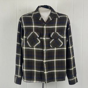 May include: A long-sleeved plaid shirt with a button-down collar. The shirt is green, white, and blue.
