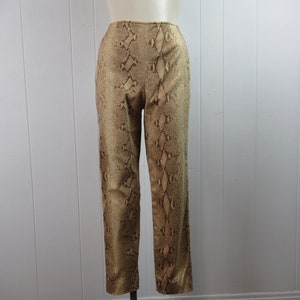 May include: A pair of brown and gold snakeskin print pants. The pants have a high waist and a straight leg.