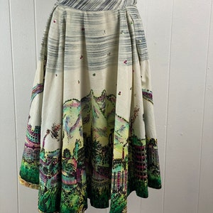 May include: A white full skirt with a colorful city scene print. The skirt has a black waistband and is decorated with sequins.