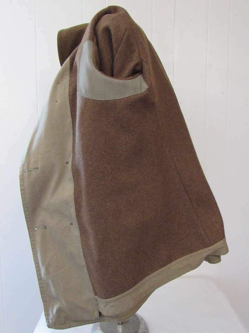 May include: A brown wool jacket with a beige lining. The jacket has a single-breasted closure and a patch pocket on the left side.