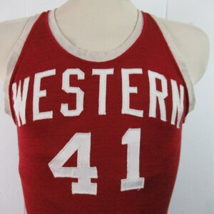 May include: Red basketball jersey with white trim and the word "WESTERN" and the number "41" in white.