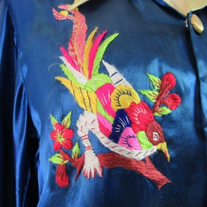 May include: A blue silk shirt with colorful embroidered bird and floral designs.