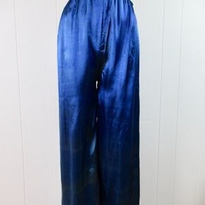 May include: Blue satin pants with a gold trim around the waist and legs.