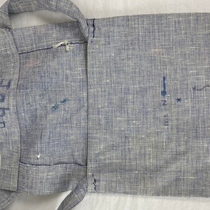 May include: A blue and white fabric bag with a strap. The bag has a flap that folds over and closes with a button. The bag is marked with the letters "L" and "H" on the strap.