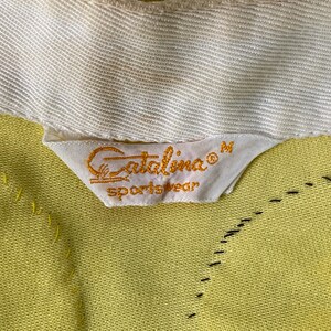 May include: A yellow Catalina sportswear label with the text "Catalina&reg; Sportswear" and the size "M" in white.
