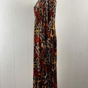 Puede incluir: Un vestido largo de manga larga con cuello en V y estampado de animales en marr&oacute;n, negro y amarillo.