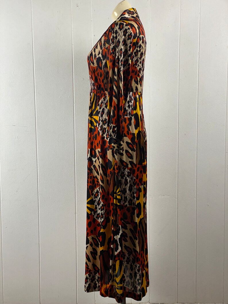Puede incluir: Un vestido largo de manga larga con cuello en V y estampado de animales en marr&oacute;n, negro y amarillo.