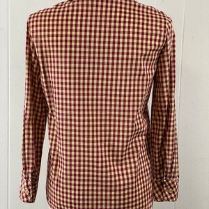 May include: A red and cream gingham button-down shirt with long sleeves.