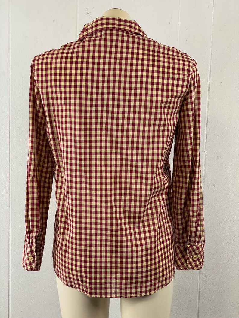 May include: A red and cream gingham button-down shirt with long sleeves.
