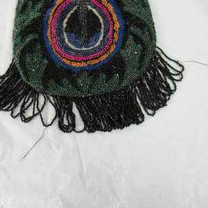 Puede incluir: Un bolso de cuentas negras con un dise&ntilde;o circular de colores y una franja de cuentas negras.
