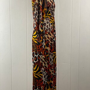 Puede incluir: Un vestido de manga larga con estampado de animales en marr&oacute;n, naranja, amarillo y negro. El vestido tiene cuello y cierre de botones en la parte delantera.
