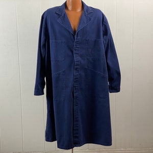 Puede incluir: Una chaqueta de trabajo azul marino de manga larga con cierre de botones y varios bolsillos.