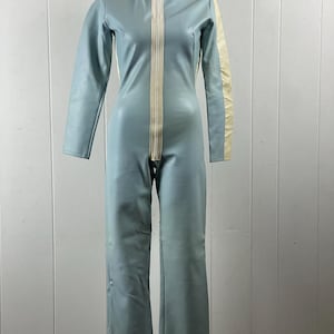 K&ouml;nnte beinhalten: Ein hellblauer Overall mit einem wei&szlig;en Rei&szlig;verschluss und einem wei&szlig;en Streifen an der Seite jedes Beins.