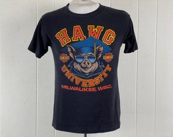 May include: Black t-shirt with a graphic of a pig wearing a graduation cap and sunglasses. The text "HAWG UNIVERSITY MILWAUKEE, WISC." is printed below the pig.