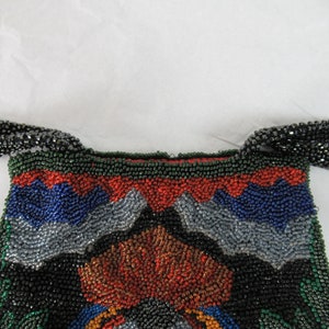 Puede incluir: Un bolso de noche de cuentas con un patr&oacute;n geom&eacute;trico en tonos de verde, azul, rojo y plateado. El bolso tiene una larga correa de cadena de cuentas.