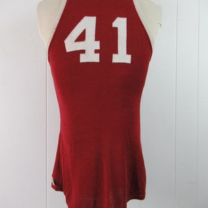 May include: Red basketball jersey with white trim and the number 41 on the back.