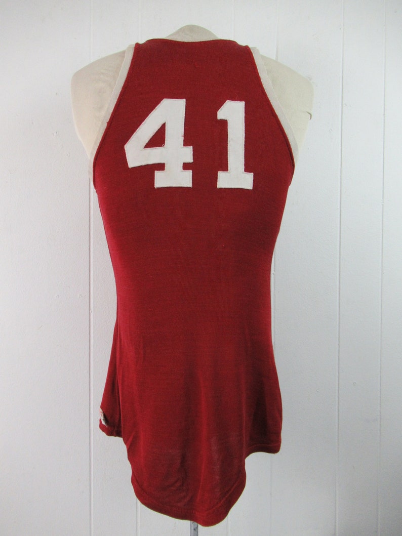 May include: Red basketball jersey with white trim and the number 41 on the back.
