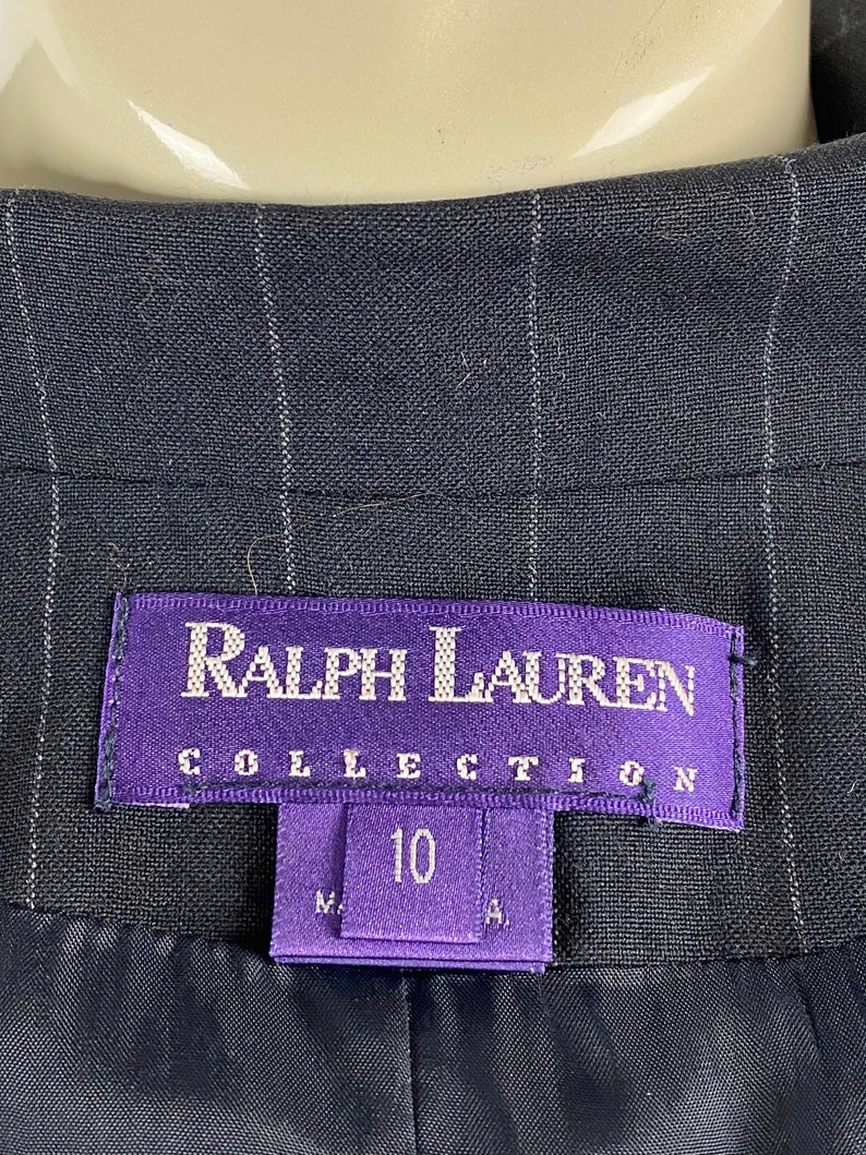 May include: A black and white striped blazer with a purple label that reads "Ralph Lauren Collection" and a size tag that says "10".