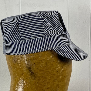 May include: A blue and white striped cotton cap with a stiff brim. The cap has a simple design and is made of a durable material.