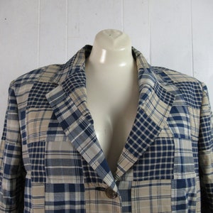 May include: A blue and beige plaid blazer with a single button closure. The blazer is made of a lightweight fabric and has a relaxed fit.