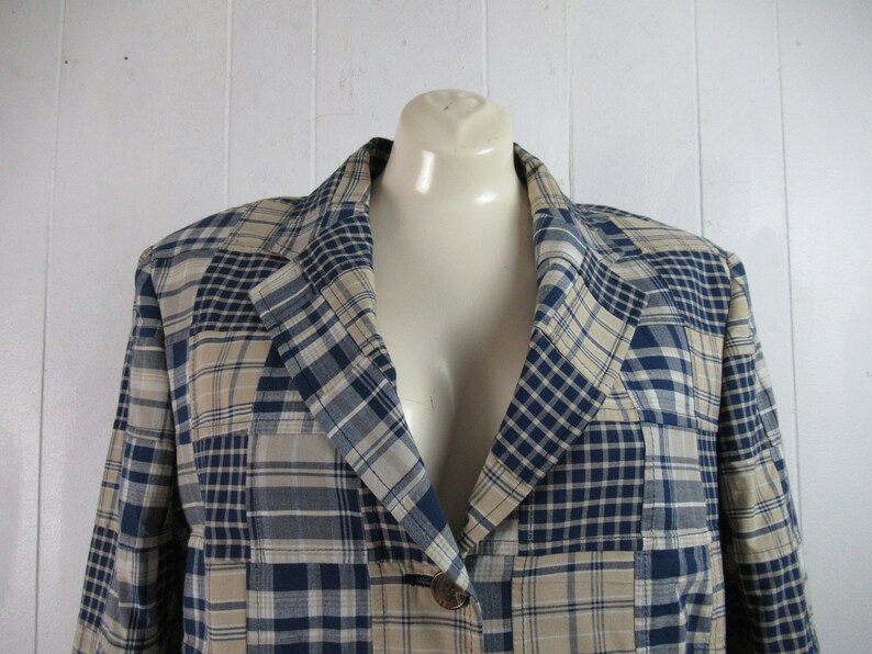 May include: A blue and beige plaid blazer with a single button closure. The blazer is made of a lightweight fabric and has a relaxed fit.