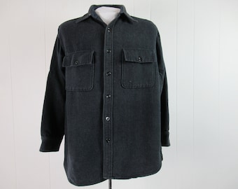 May include: A black long-sleeved flannel shirt with button-up closure and two large flap pockets on the chest.
